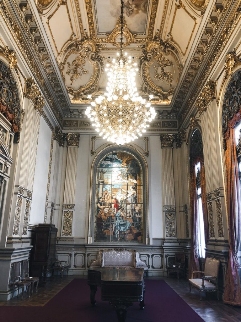 Gilded salon with chandelier and stained glass